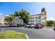 Condo building exterior featuring a beige facade, red roof, and decorative clock tower detail at 2430 Florentine Way # 40, Clearwater, FL 33763