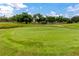 Golf course green with a flag, sand trap, and floral decorations, part of a beautiful community setting at 2430 Florentine Way # 40, Clearwater, FL 33763