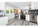 Bright kitchen with stainless steel appliances, white cabinetry, granite countertops and view into the living area at 2430 Florentine Way # 40, Clearwater, FL 33763