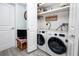 Convenient laundry room with modern washer and dryer, storage, and additional shelving at 2430 Florentine Way # 40, Clearwater, FL 33763