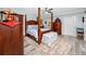 Spacious main bedroom with a four-poster bed, sitting bench, and wood-look flooring at 2430 Florentine Way # 40, Clearwater, FL 33763