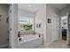 Bathroom features a garden tub, ceramic tile, and natural light from a window with garden view at 2511 Groveway Dr, Valrico, FL 33596