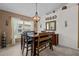 This dining room offers a dark wood table, bench, chandelier, and large sunny window at 2511 Groveway Dr, Valrico, FL 33596