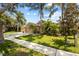 Inviting single-Gathering home with lush landscaping, mature palms, and a well-maintained lawn on a sunny day at 2511 Groveway Dr, Valrico, FL 33596