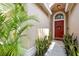 Welcoming entryway with a bright red door and lush greenery, creating a warm and inviting curb appeal at 2511 Groveway Dr, Valrico, FL 33596