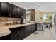 Spacious kitchen includes dark cabinetry, tile backsplash, stone countertops, and stainless dishwasher at 2511 Groveway Dr, Valrico, FL 33596
