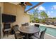 Covered lanai with dining and tv overlooking a pool area with plenty of seating at 2511 Groveway Dr, Valrico, FL 33596