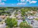 Overhead view of a residential area with mature trees, colorful homes, and backyard swimming pools at 2533 Blossom Lake Dr, Holiday, FL 34691