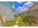 A quaint backyard features stepping stones, a wooden fence, and tropical plants at 2533 Blossom Lake Dr, Holiday, FL 34691