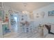 Cozy dining area featuring a chandelier, light wood floors, and adjacent kitchen access at 2533 Blossom Lake Dr, Holiday, FL 34691