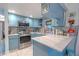 Stylish kitchen featuring blue cabinets, stainless steel appliances, and elegant countertops, perfect for cooking at 2533 Blossom Lake Dr, Holiday, FL 34691
