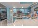 Bright kitchen with stainless steel appliances, blue cabinets and open layout connecting to other living areas at 2533 Blossom Lake Dr, Holiday, FL 34691