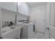 Bright laundry room with white washer and dryer, utility sink and white cabinets at 2533 Blossom Lake Dr, Holiday, FL 34691