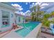 Enjoy this backyard pool with tropical landscaping, seating area, and playful murals on the house at 2533 Blossom Lake Dr, Holiday, FL 34691