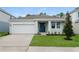 Charming one-story home featuring a two-car garage, manicured lawn, and welcoming front entry at 2791 Peake St, North Port, FL 34286