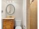 Compact bathroom featuring wooden vanity, stylish mirror, tile shower and toilet at 304 21St N Ave, St Petersburg, FL 33704