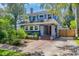 Charming two-story home featuring blue siding, brick accents, a red front door, and mature trees in a well-maintained yard at 304 21St N Ave, St Petersburg, FL 33704