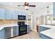 Well-lit kitchen featuring stainless steel appliances, blue cabinets and tile flooring at 304 21St N Ave, St Petersburg, FL 33704
