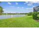 A tranquil lake surrounded by lush green grass offers a serene backyard view at 3326 Woodmont Dr, Parrish, FL 34219