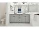 Bathroom showcasing grey cabinets, double vanity, modern fixtures and marble floors at 3326 Woodmont Dr, Parrish, FL 34219