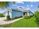 Charming blue home with lush landscaping and a welcoming walkway at 3326 Woodmont Dr, Parrish, FL 34219