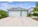 Beautifully landscaped blue home featuring a two-car garage and well-manicured lawn at 3326 Woodmont Dr, Parrish, FL 34219