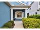 Charming blue home featuring a cozy covered front porch and lush landscaping at 3326 Woodmont Dr, Parrish, FL 34219