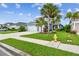 A charming blue home with a well-manicured lawn and mature palm trees at 3326 Woodmont Dr, Parrish, FL 34219
