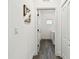 Hallway leading to the laundry room, featuring wood floors at 3326 Woodmont Dr, Parrish, FL 34219