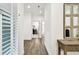 Hallway featuring hardwood floors, white paint, and modern, decorative cabinet with mirrors at 3326 Woodmont Dr, Parrish, FL 34219