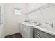 Well-lit laundry room with a washer, dryer, sink, and wire shelving at 3326 Woodmont Dr, Parrish, FL 34219