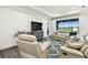 Inviting living room area featuring leather seating, a rug, and a view of a lake at 3326 Woodmont Dr, Parrish, FL 34219