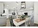 Open-concept living space with dining area, kitchen featuring gray cabinets and island, and staircase to the second floor at 3326 Woodmont Dr, Parrish, FL 34219