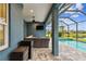 Covered patio with mounted television and outdoor kitchen space at 3326 Woodmont Dr, Parrish, FL 34219
