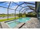 Screened pool and spa overlooking a pond in a backyard with beautiful landscaping at 3326 Woodmont Dr, Parrish, FL 34219