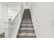 A carpeted staircase with white banisters ascends to the upper level of the home at 3326 Woodmont Dr, Parrish, FL 34219