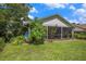 Landscaped backyard with lush lawn and screened in porch for outdoor enjoyment at 3335 Foxridge Cir, Tampa, FL 33618