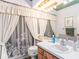 Bright bathroom with a single sink vanity, tub/shower combo with patterned shower curtain, and updated fixtures at 3335 Foxridge Cir, Tampa, FL 33618