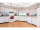 Bright kitchen features white cabinetry, appliances, wood floors and double windows for ample natural light at 3335 Foxridge Cir, Tampa, FL 33618