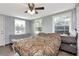 Bedroom with a large bed, windows, ceiling fan, and hard wood floors at 3426 Coldwell Dr, Holiday, FL 34691