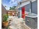 Cozy patio area with seating, a red door, and an air conditioning unit at 3426 Coldwell Dr, Holiday, FL 34691