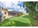 Well maintained backyard featuring lush landscaping, a putting green, and an outdoor screened-in pool at 3437 Aspen Trl, Clearwater, FL 33761