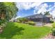 Well maintained backyard featuring a pool, lush landscaping, outdoor fireplace, and putting green at 3437 Aspen Trl, Clearwater, FL 33761