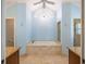 Open bathroom featuring soaking tub, chandelier, granite counters, and travertine tile at 3437 Aspen Trl, Clearwater, FL 33761