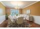 Dining room featuring a table set for eight with contemporary chandelier and classic wainscoting at 3437 Aspen Trl, Clearwater, FL 33761