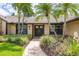 Close up of a charming home with lush landscaping, mature plants, and well maintained walkway at 3437 Aspen Trl, Clearwater, FL 33761
