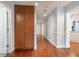 Hallway with hardwood floors, built-in wood cabinet, white doors and trim and contemporary lighting at 3437 Aspen Trl, Clearwater, FL 33761