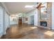 Open-concept living room with hardwood floors, ceiling fan, skylight, and a seamless flow to the kitchen at 3437 Aspen Trl, Clearwater, FL 33761