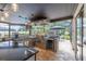 Outdoor kitchen with stainless grill, granite counters, and a picturesque view of the backyard oasis at 3437 Aspen Trl, Clearwater, FL 33761