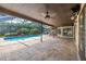 Covered patio with picturesque view of the swimming pool, backyard bar and green foliage at 3437 Aspen Trl, Clearwater, FL 33761